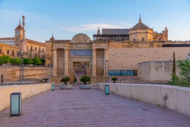 İspanya 'nın Cordoba şehrinde, ufukta La mezquita katedrali olan eski Roma köprüsünün gündoğumu manzarası.