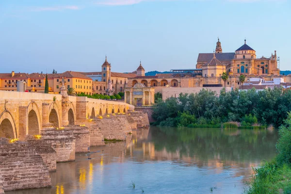 İspanya 'nın Cordoba şehrinde, ufukta La mezquita katedrali olan eski Roma köprüsünün gündoğumu manzarası.