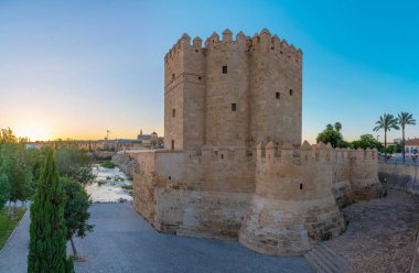 İspanya 'nın Cordob şehrindeki La mezquita katedrali ve kalahorra kulesiyle Guadalquivir nehri üzerindeki aydınlatılmış Roma köprüsünün gece görüşü.