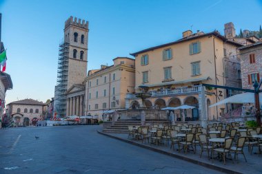 İtalyan kasabası Assisi 'nin merkezinde Piazza del Comune üzerinde gün doğumu.