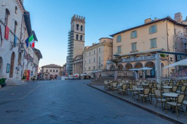 İtalyan kasabası Assisi 'nin merkezinde Piazza del Comune üzerinde gün doğumu.