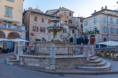 İtalyan kasabası Assisi 'nin merkezinde Piazza del Comune üzerinde gün doğumu.