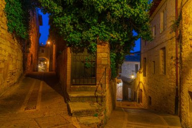 İtalya 'nın eski Assisi kasabasında dar bir sokakta gün batımı.