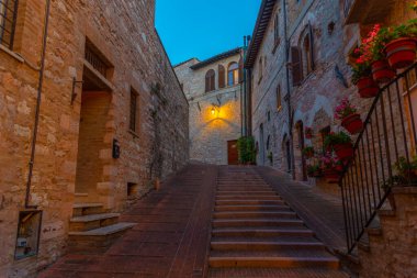 İtalya 'nın eski Assisi kasabasında dar bir sokakta gün batımı.