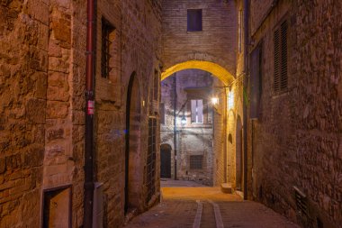 İtalya 'nın eski Assisi kasabasında dar bir sokakta gün batımı.