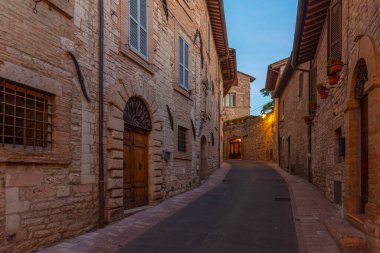 İtalya 'nın eski Assisi kasabasında dar bir sokakta gün batımı.