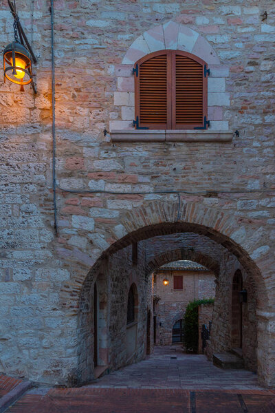 Sunset over a narrow street in the old town of Assisi in Italy.