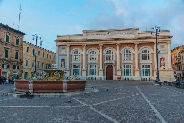 Pesaro, İtalya 'da Postane sarayı ve Neptün çeşmesiyle Piazza del Popolo' nun gündoğumu manzarası.