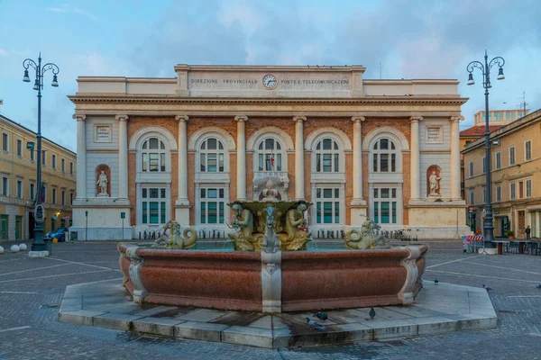 Pesaro, İtalya 'da Postane sarayı ve Neptün çeşmesiyle Piazza del Popolo' nun gündoğumu manzarası.