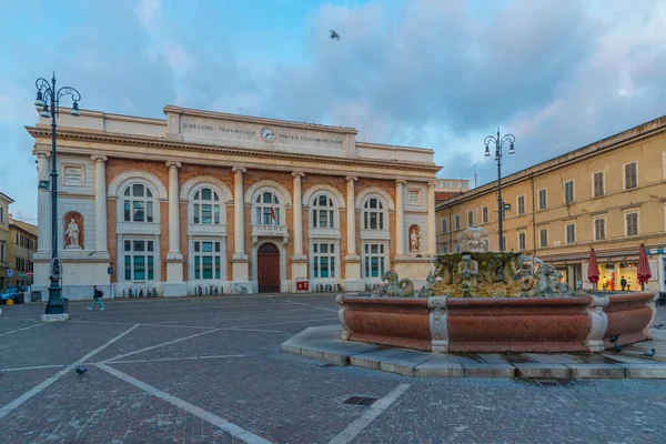 Pesaro, İtalya 'da Postane sarayı ve Neptün çeşmesiyle Piazza del Popolo' nun gündoğumu manzarası.