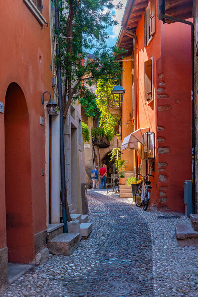 People are strolling thorugh a street in Malcesine in Italy.