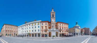 Rimini, İtalya, 2 Eylül 2021: İnsanlar İtalya 'nın Rimini şehrindeki Piazza Martiri' de bir saat kulesinin önünden geçiyorlar.