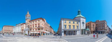 Rimini, İtalya, 2 Eylül 2021: İnsanlar İtalya 'nın Rimini şehrindeki Piazza Martiri' de bir saat kulesinin önünden geçiyorlar..