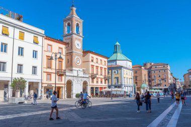 Rimini, İtalya, 2 Eylül 2021: İnsanlar İtalya 'nın Rimini şehrindeki Piazza Martiri' de bir saat kulesinin önünden geçiyorlar..