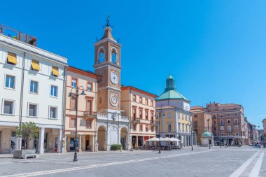 Rimini, İtalya, 2 Eylül 2021: İnsanlar İtalya 'nın Rimini şehrindeki Piazza Martiri' de bir saat kulesinin önünden geçiyorlar..