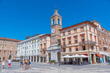 Rimini, İtalya, 2 Eylül 2021: İnsanlar İtalya 'nın Rimini şehrindeki Piazza Martiri' de bir saat kulesinin önünden geçiyorlar..