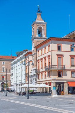 Rimini, İtalya, 2 Eylül 2021: İnsanlar İtalya 'nın Rimini şehrindeki Piazza Martiri' de bir saat kulesinin önünden geçiyorlar..