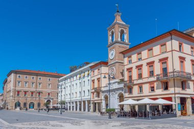 Rimini, İtalya, 2 Eylül 2021: İnsanlar İtalya 'nın Rimini şehrindeki Piazza Martiri' de bir saat kulesinin önünden geçiyorlar..