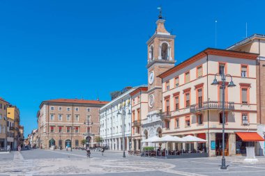 Rimini, İtalya, 2 Eylül 2021: İnsanlar İtalya 'nın Rimini şehrindeki Piazza Martiri' de bir saat kulesinin önünden geçiyorlar..