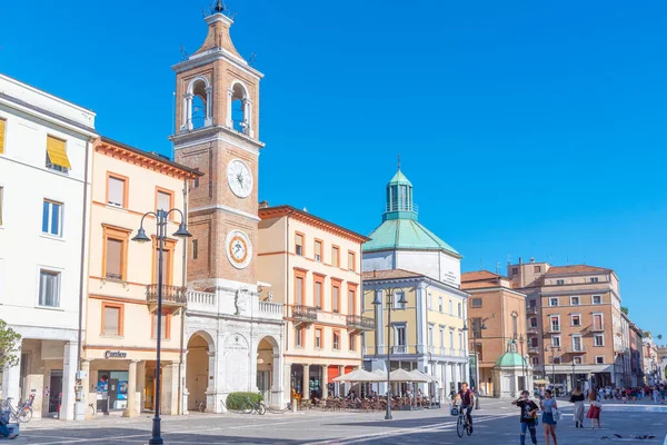 Rimini, İtalya, 2 Eylül 2021: İnsanlar İtalya 'nın Rimini şehrindeki Piazza Martiri' de bir saat kulesinin önünden geçiyorlar..