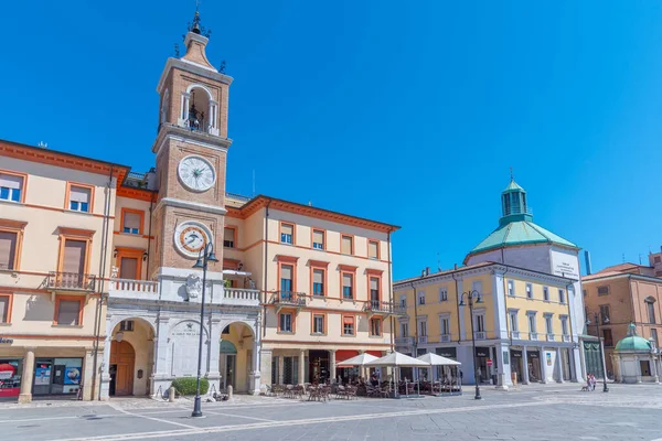 Rimini, İtalya, 2 Eylül 2021: İnsanlar İtalya 'nın Rimini şehrindeki Piazza Martiri' de bir saat kulesinin önünden geçiyorlar..