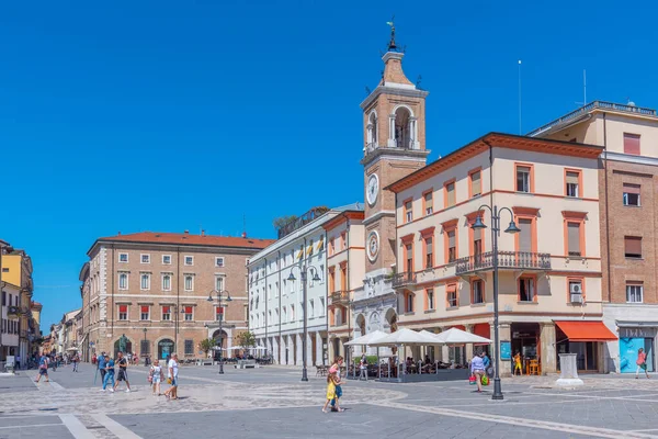 Rimini, İtalya, 2 Eylül 2021: İnsanlar İtalya 'nın Rimini şehrindeki Piazza Martiri' de bir saat kulesinin önünden geçiyorlar..