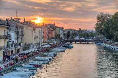 Peschiera del Garda, İtalya, 26 Ağustos 2021: İtalyan kenti Peschiera del Garda 'da Canale di Mezzo' nun günbatımı manzarası.
