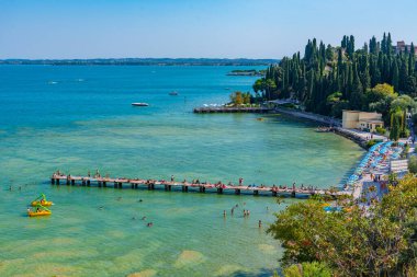 Sirmione, İtalya, 26 Ağustos 2021: İnsanlar İtalya 'nın Sirmione kentindeki Lido delle Bionde plajında güneşli bir günün tadını çıkarıyorlar..