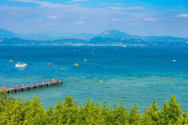 Sirmione, İtalya, 26 Ağustos 2021: İnsanlar İtalya 'nın Sirmione kentindeki Lido delle Bionde plajında güneşli bir günün tadını çıkarıyorlar..