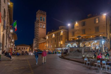 Assisi, İtalya, 2 Ekim 2021: İtalyan kasabası Assisi 'nin merkezinde Piazza del Comune' un gece manzarası.