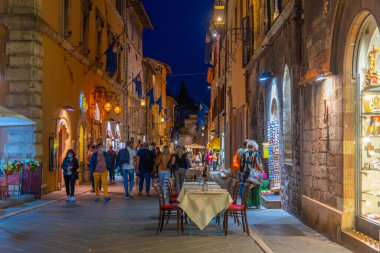 Assisi, İtalya, 2 Ekim 2021: Corso Giuseppe Manzinni 'nin İtalya' daki eski Assisi kasabasındaki gece manzarası.
