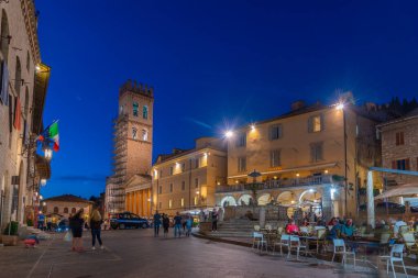 Assisi, İtalya, 2 Ekim 2021: İtalyan kasabası Assisi 'nin merkezinde Piazza del Comune' un gece manzarası.
