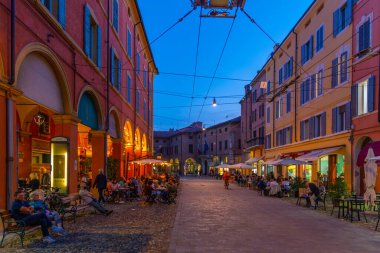 Modena, İtalya, 22 Eylül 2021: İtalyan kenti Modena 'nın merkezindeki ticari bir caddenin gün batımı manzarası.