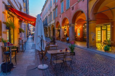 Modena, İtalya, 22 Eylül 2021: İtalyan kenti Modena 'nın merkezindeki ticari bir caddenin gün batımı manzarası.