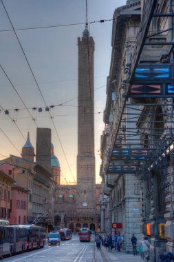 Bologna, İtalya, 22 Eylül 2021: Bologna 'nın iki kulesi - Torre Garisenda ve Torre Degli Asinelli - Francesco Rizzoli üzerinden aydınlananların gece görüşü.