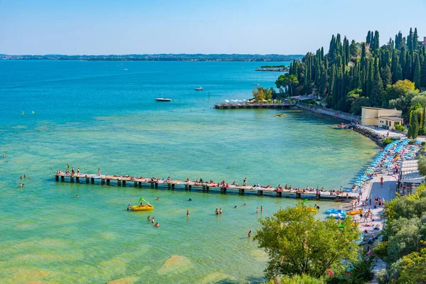 Sirmione, İtalya, 26 Ağustos 2021: İnsanlar İtalya 'nın Sirmione kentindeki Lido delle Bionde plajında güneşli bir günün tadını çıkarıyorlar..