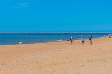 Huelva, İspanya, 21 Mayıs 2021: İnsanlar Huelva, İspanya yakınlarındaki bir plajda güneşli bir günün tadını çıkarıyorlar