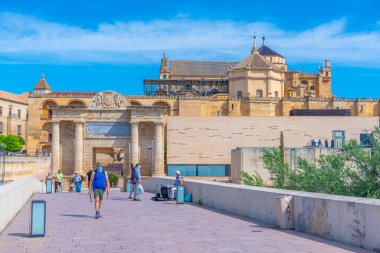Cordoba, İspanya, 25 Mayıs 2021: İnsanlar İspanya 'nın Cordoba kentindeki Roma köprüsünden geçerek La mezquita katedraline doğru yürüyorlar..