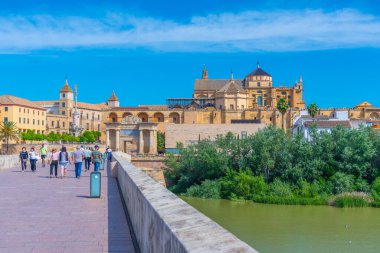 Cordoba, İspanya, 25 Mayıs 2021: İnsanlar İspanya 'nın Cordoba kentindeki Roma köprüsünden geçerek La mezquita katedraline doğru yürüyorlar..