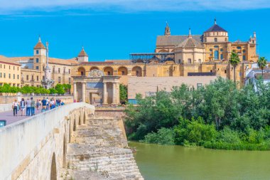 Cordoba, İspanya, 25 Mayıs 2021: İnsanlar İspanya 'nın Cordoba kentindeki Roma köprüsünden geçerek La mezquita katedraline doğru yürüyorlar..