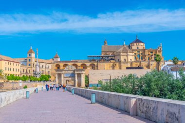 Cordoba, İspanya, 25 Mayıs 2021: İnsanlar İspanya 'nın Cordoba kentindeki Roma köprüsünden geçerek La mezquita katedraline doğru yürüyorlar..