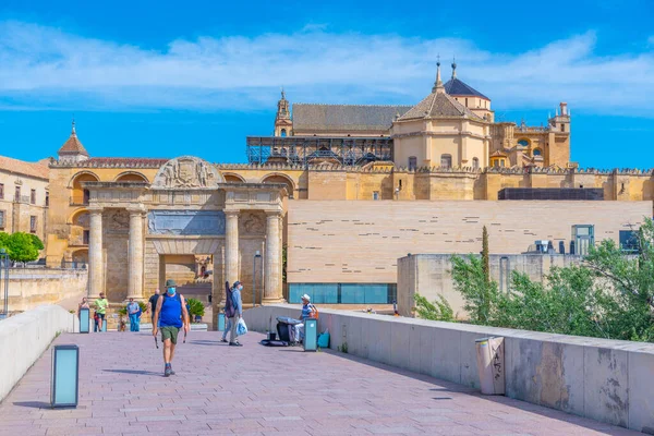 Cordoba, İspanya, 25 Mayıs 2021: İnsanlar İspanya 'nın Cordoba kentindeki Roma köprüsünden geçerek La mezquita katedraline doğru yürüyorlar..