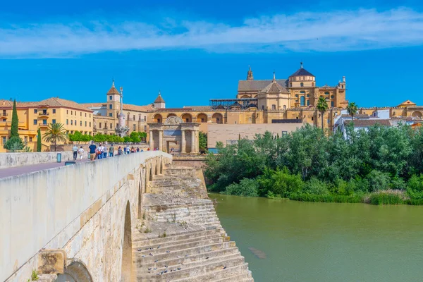 Cordoba, İspanya, 25 Mayıs 2021: İnsanlar İspanya 'nın Cordoba kentindeki Roma köprüsünden geçerek La mezquita katedraline doğru yürüyorlar..