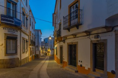 Evora, Portekiz, 14 Haziran 2021: Portekiz 'in Evora kasabasındaki dar bir caddenin gece görüşü.