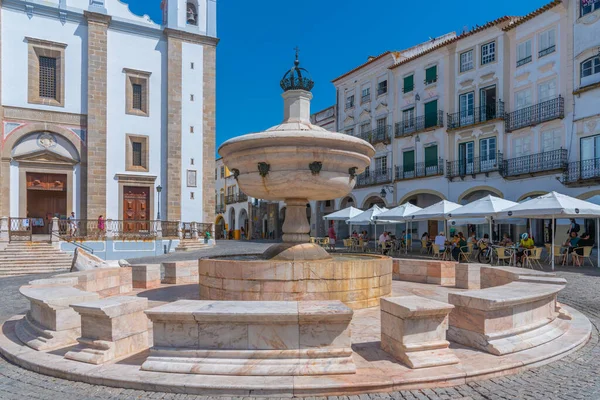 Evora, Portekiz, 15 Haziran 2021: İnsanlar Portekiz 'in Evora kentindeki Praca do Giraldo Meydanı' nda güneşli bir günün tadını çıkarıyorlar..