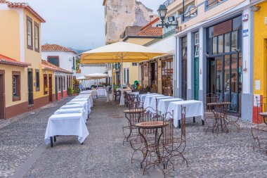 Funchal, Portekiz, 12 Haziran 2021: Portekiz 'in Funchal kasabasındaki bir caddedeki restoranlar.