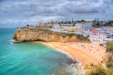 İnsanlar Portekiz 'deki Praia de Carvoeiro plajında güneşleniyor..