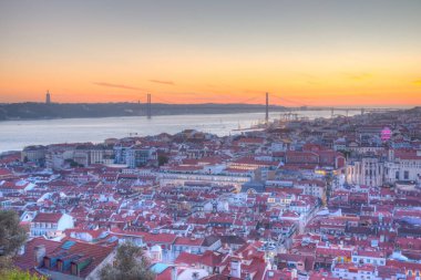 25 Nisan Köprüsü 'nün gün batımı manzarası ve Lizbon, Portekiz' deki Cristo Rei Ulusal Sığınağı.