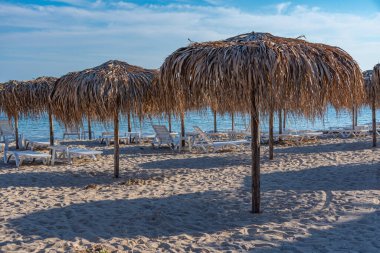 Bulgaristan 'ın Balchik kentinde plajda güneşlik ve şemsiyeler