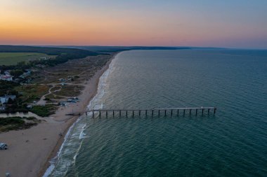 Bulgar Shkorpilovtsi köyünde gün batımı manzaralı bir iskele ve plaj